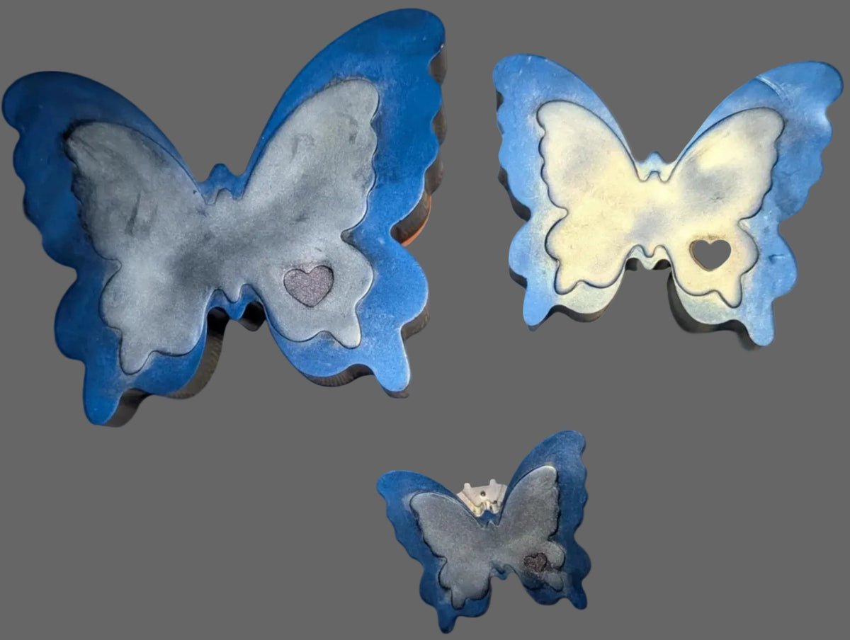 Three butterfly-shaped resin keepsakes with blue borders and silver marbled centers