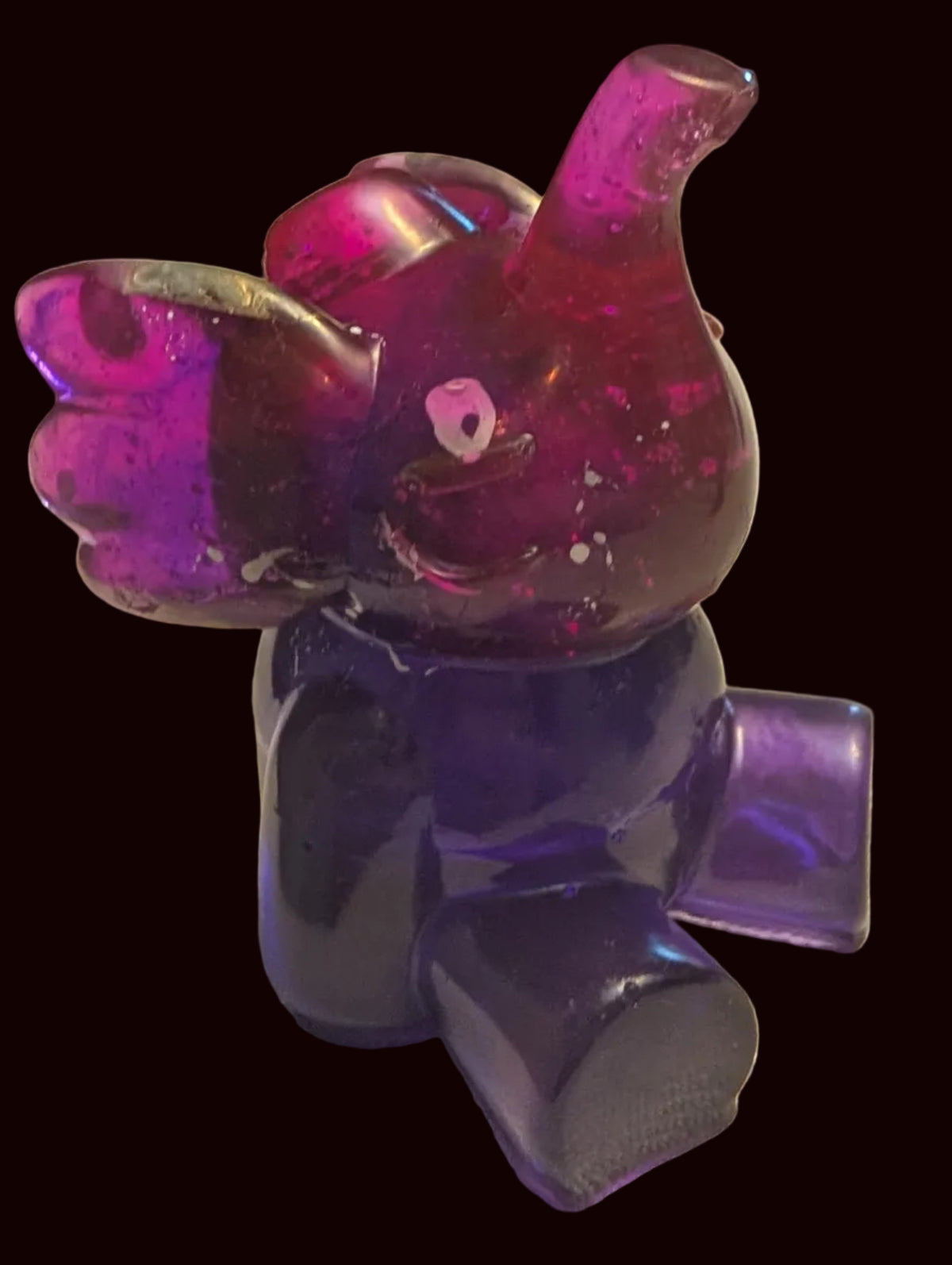 A small translucent elephant figurine in a two-tone purple and magenta color