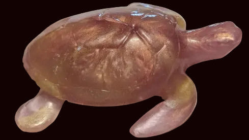 A translucent amber-colored resin sea turtle figurine with a glossy finish