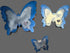 Three butterfly-shaped resin keepsakes with blue borders and silver marbled centers